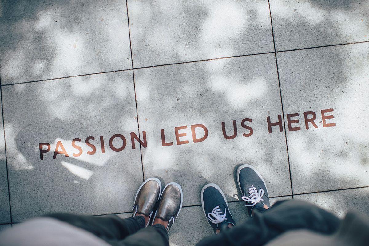 Cotora — two people standing by a ‘Passion led us here' pavement sign